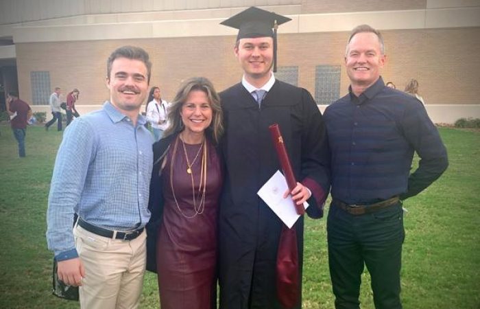 Family celebrating graduation day outdoors.